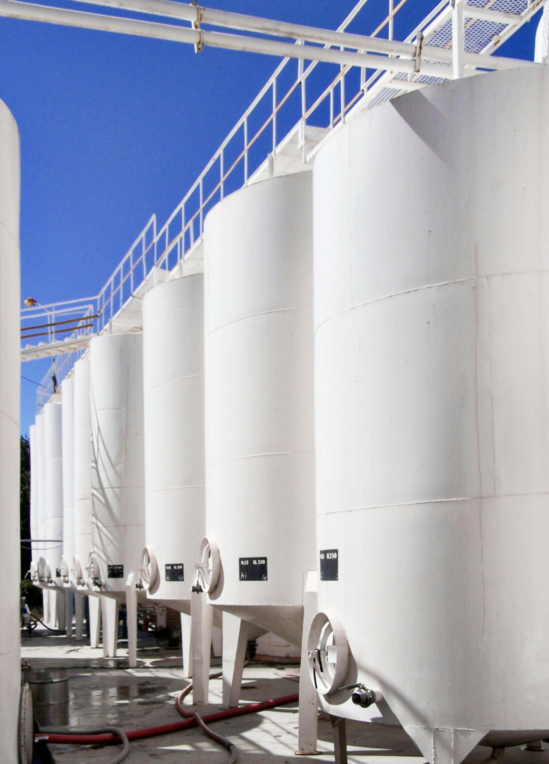 White storage tanks in an outdoor industrial setting, Cafayate, Argentina.